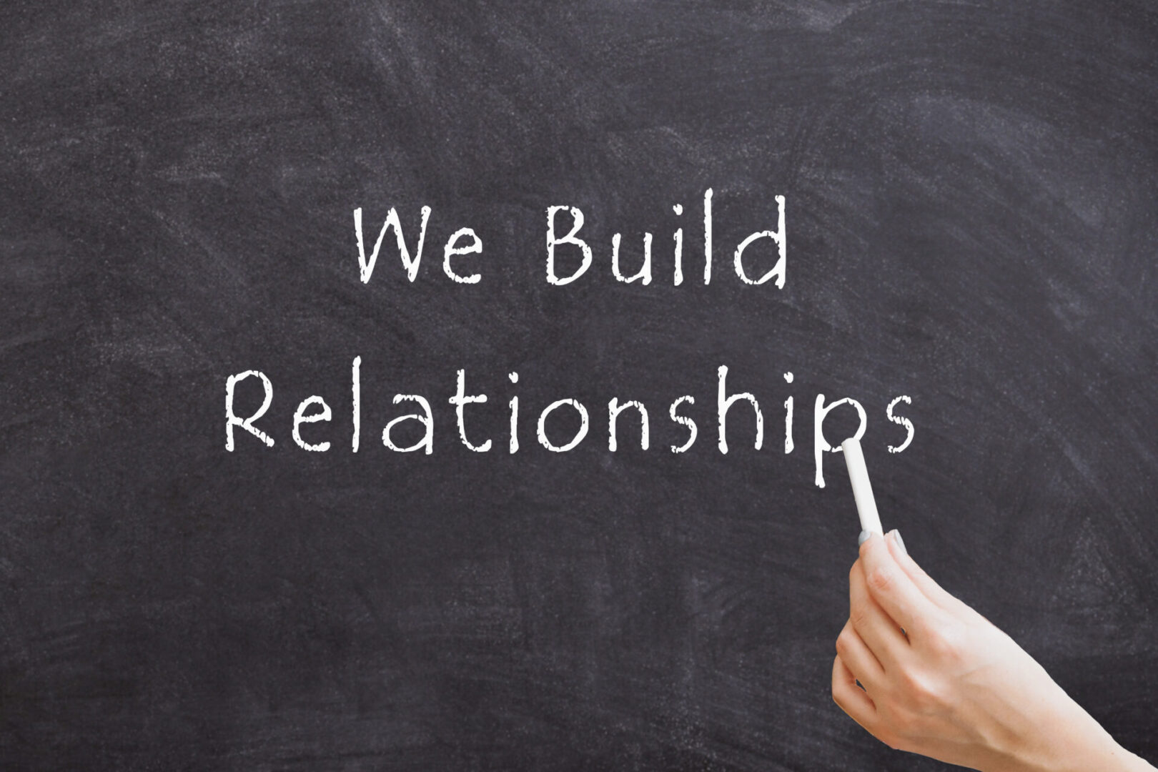 Text on chalkboard: "We Build Relationships."