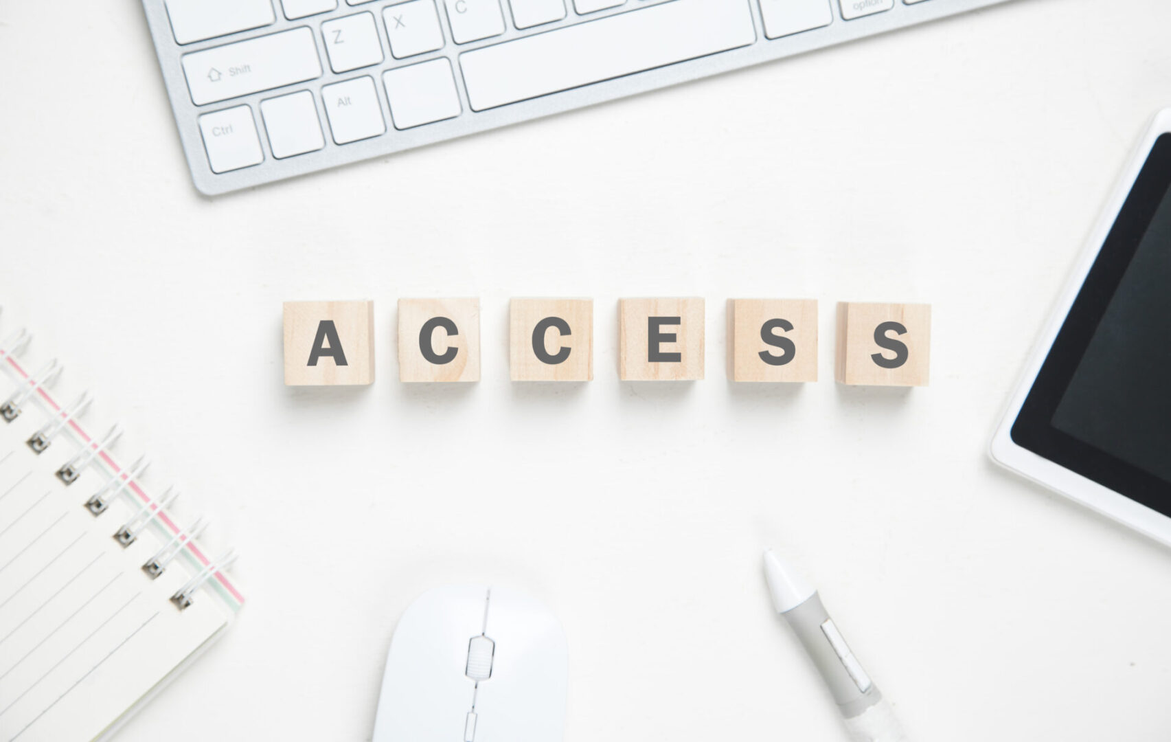 Wooden blocks spelling "ACCESS" on a desk.